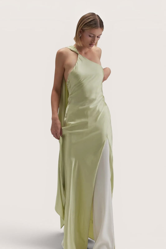 Model wearing a Pink shop by maf sage green satin asymmetrical halter maxi dress with a scarf and side slit.