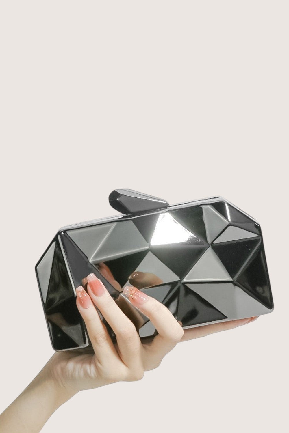 Bolso clutch geométrico negro brillante de Pink shop by maf, accesorio rígido para eventos formales y fiestas.