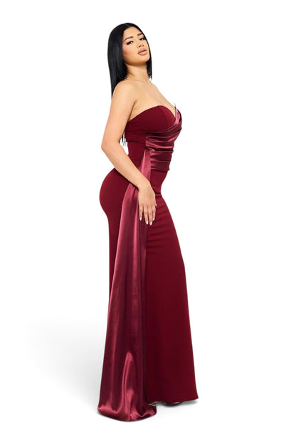 Model wearing a Pink shop by maf burgundy mermaid evening gown with a draped satin bustier and side sash