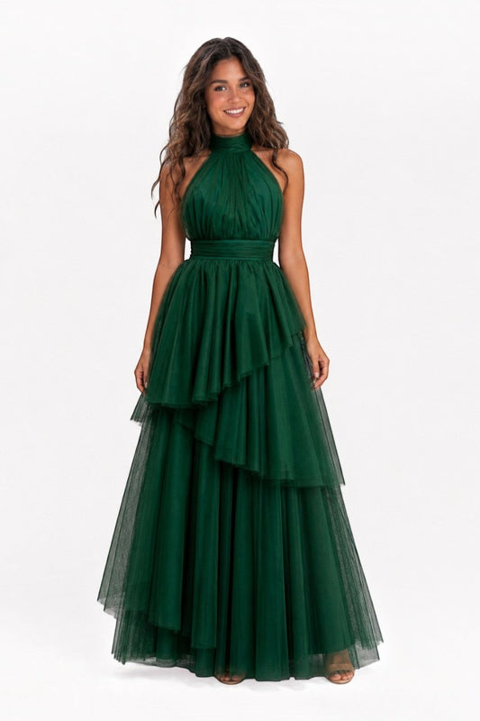 Model wearing a Pink shop by maf forest green tulle halter gown with a bow neck and asymmetrical tiered skirt.