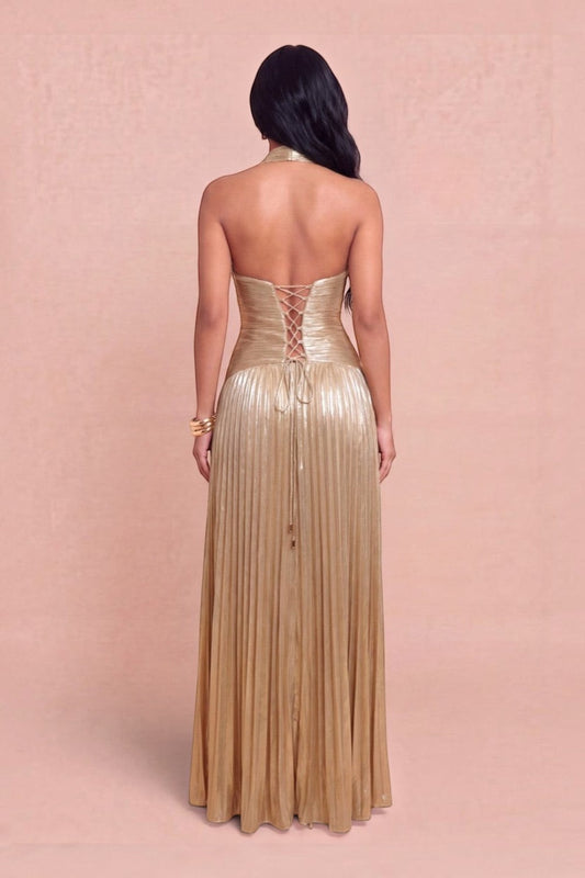 Back view of a Pink shop by maf metallic gold pleated halter gown with a lace-up corset bodice on a model
