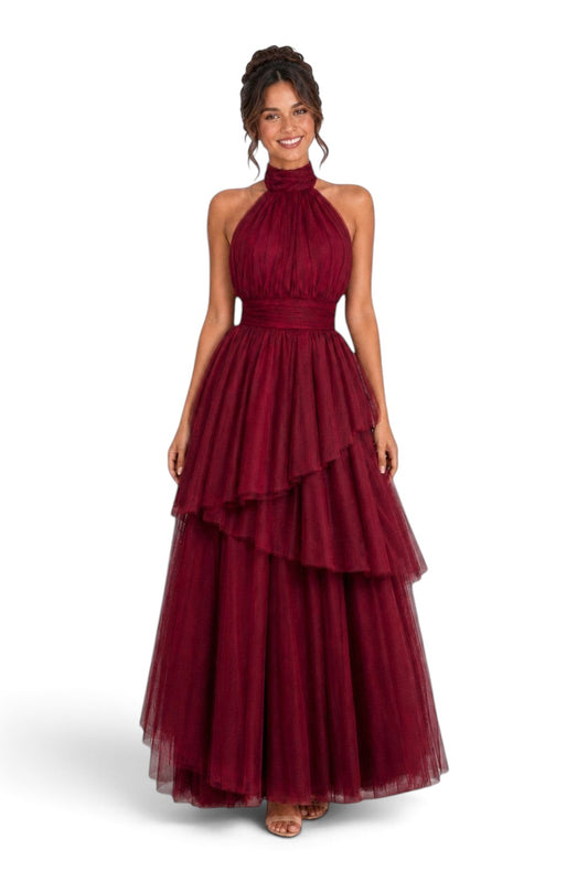 Pink shop by maf wine red tulle halter gown with tiered asymmetrical skirt and bow neck detail on a smiling model