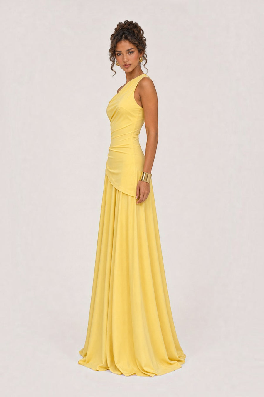 Model wearing a straw yellow Pink shop by maf one-shoulder floor-length gown with side draping and a fluid skirt.